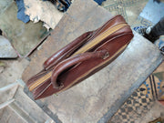 Slim brown leather work briefcase side profile showing zip track and edge stitching