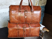 Cognac leather weekender bags in Moroccan workshop, front buckled flaps and stitched straps