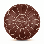 Dark brown Moroccan round leather pouf with cream floral embroidery against white
