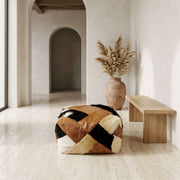 Brown leather and black-and-ivory patchwork square pouf in neutral interior