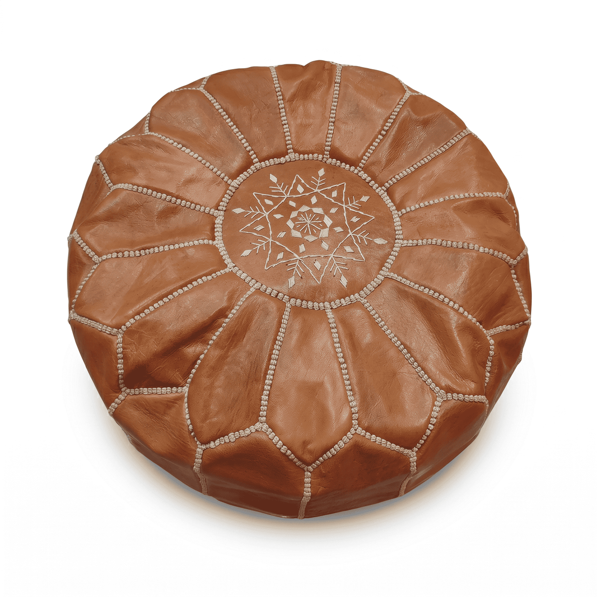 Tan Moroccan round leather pouf with cream medallion embroidery against white