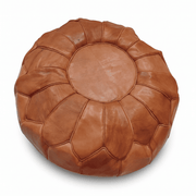 Tan Moroccan round leather pouf with petal stitching against white